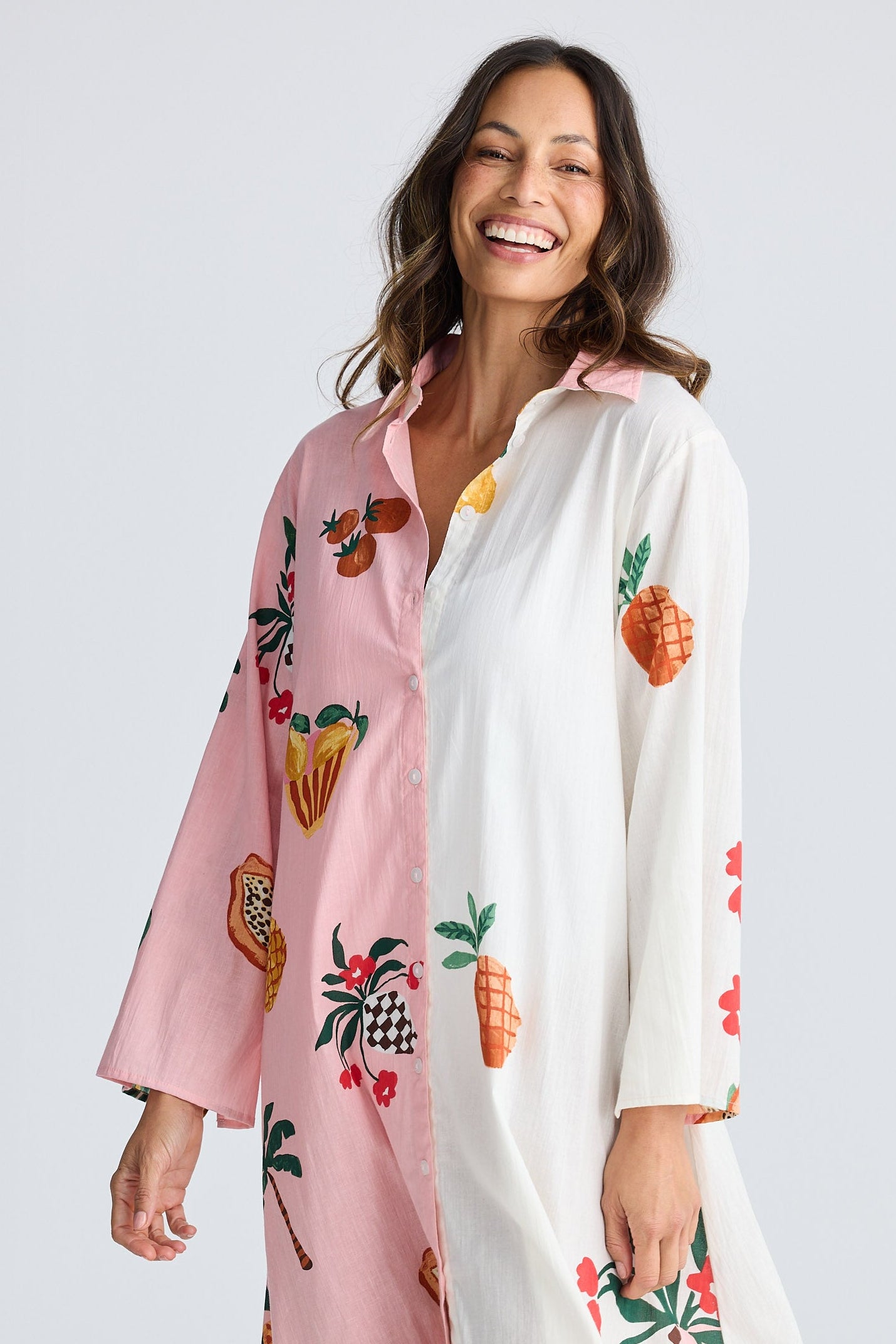 Woman wearing a colorful kimono-style garment with fruit patterns on a white background
