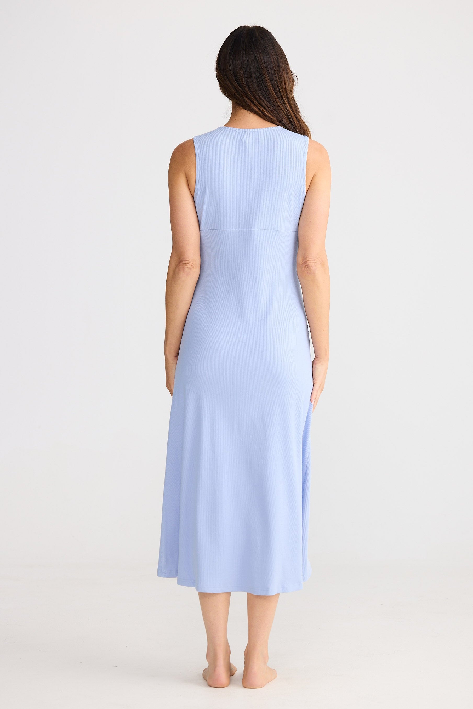Woman wearing a light blue sleeveless dress on a white background