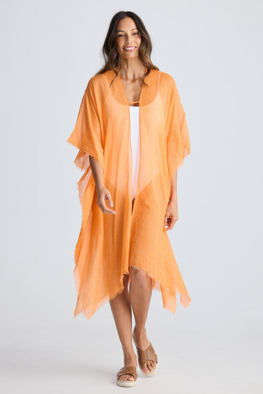 Woman wearing an orange kimono-style garment on a white background