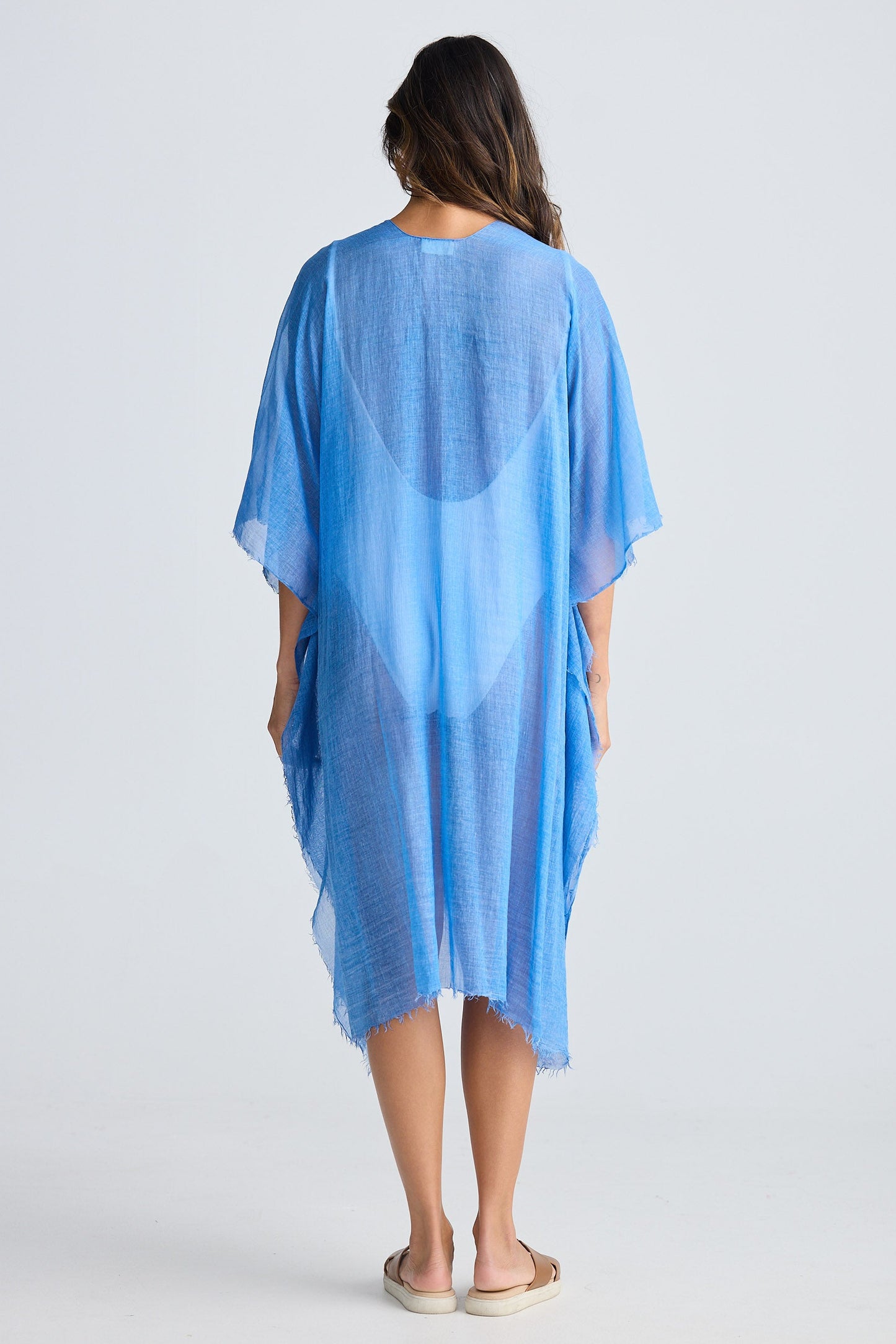 Woman wearing a blue cover-up against a white background