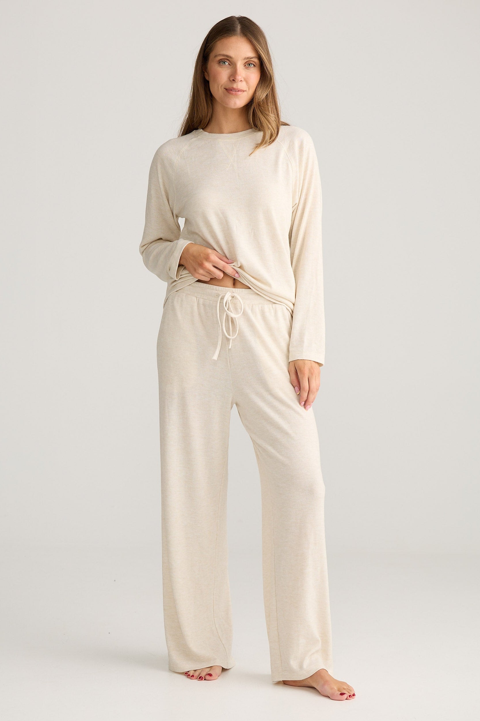 Woman wearing a beige loungewear set on a white background