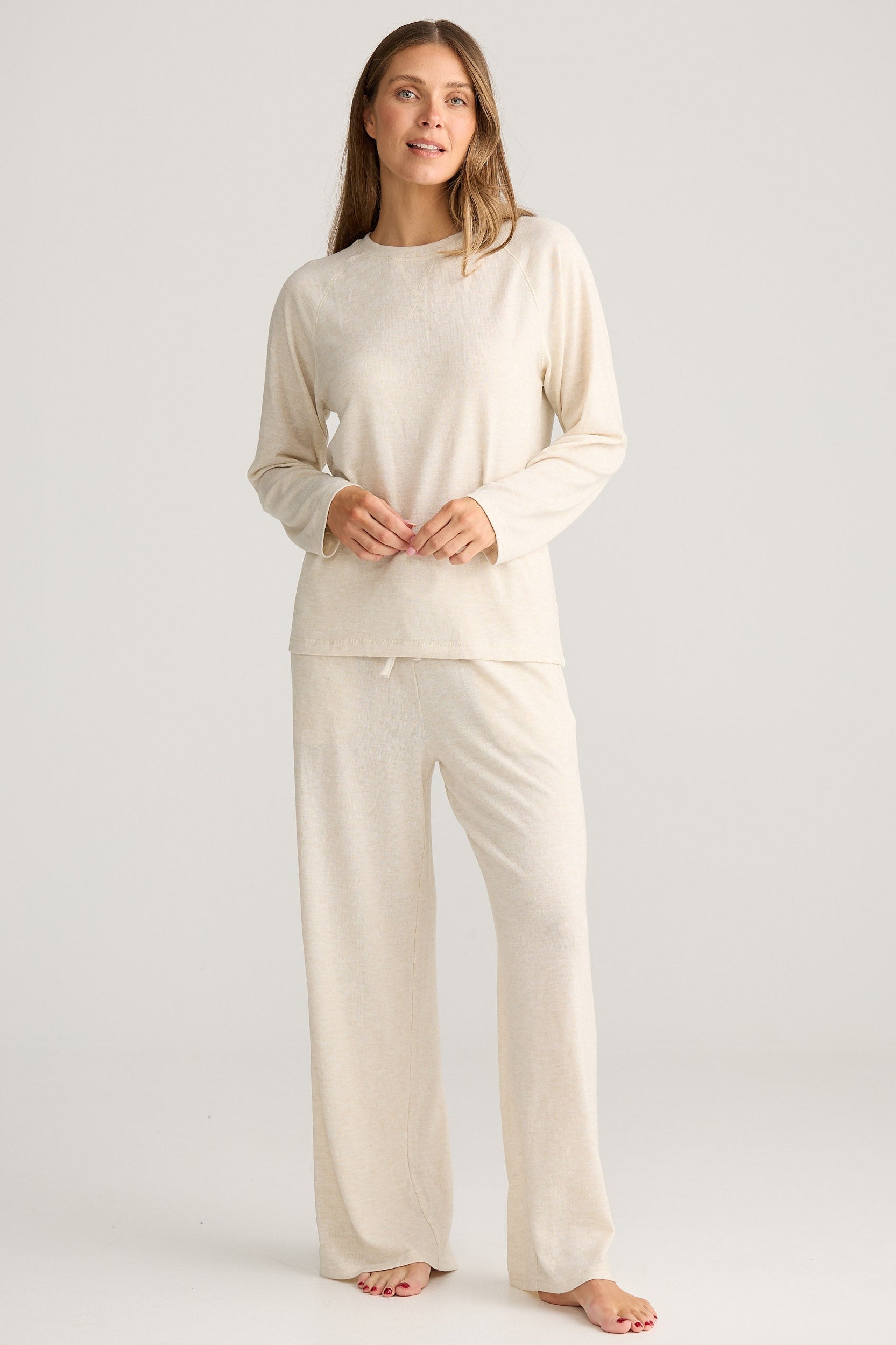 Woman wearing a beige loungewear set on a white background