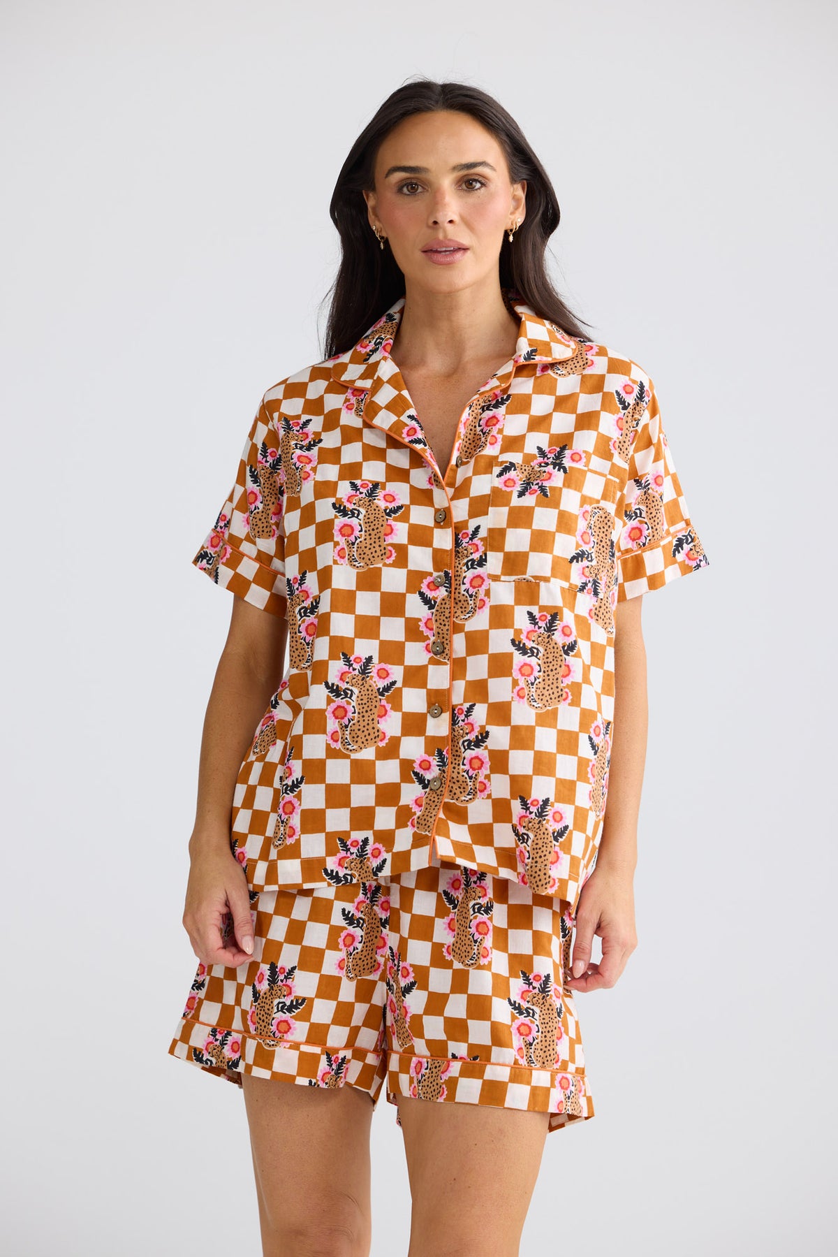 Model wearing Namaste Pyjama Set in tiger check, front view. Short-sleeve shirt with piping and matching shorts.