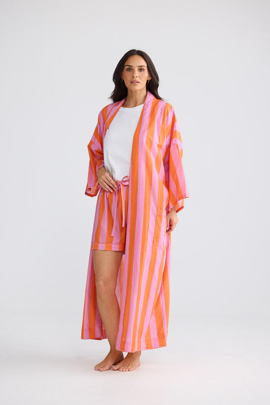 Model wearing Namaste Robe in lilac with orange stripe, open over a white tee and matching shorts.