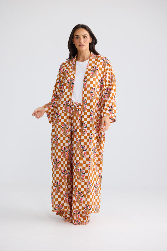 Model wearing Namaste Robe in tiger check, open over a white tee and matching pant, front view.