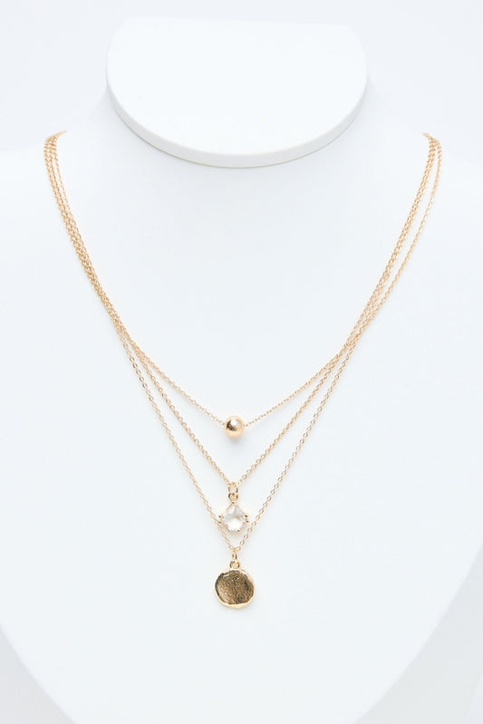 Gold necklaces on a mannequin with a white background
