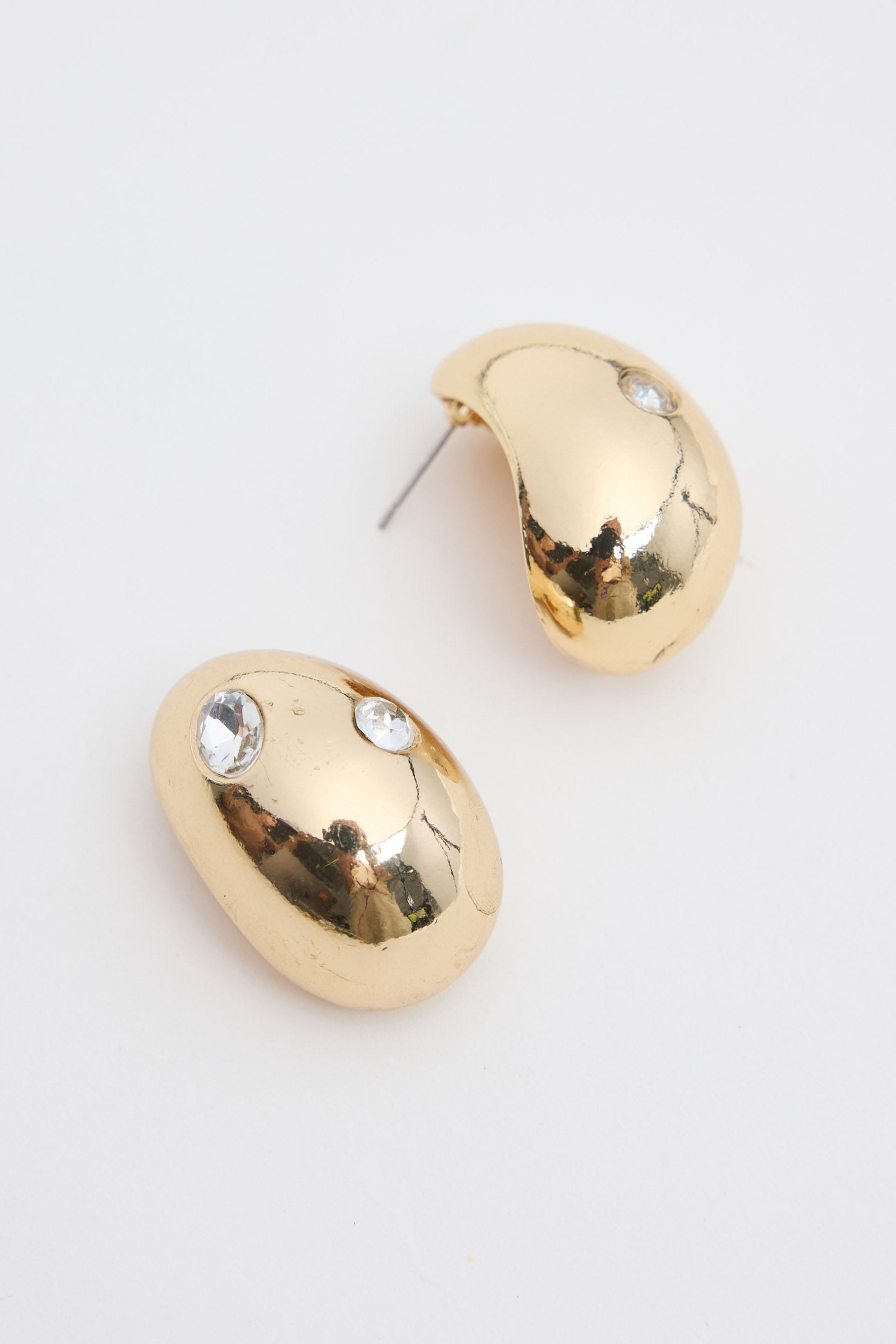 Gold hoop earrings with rhinestones on a white background