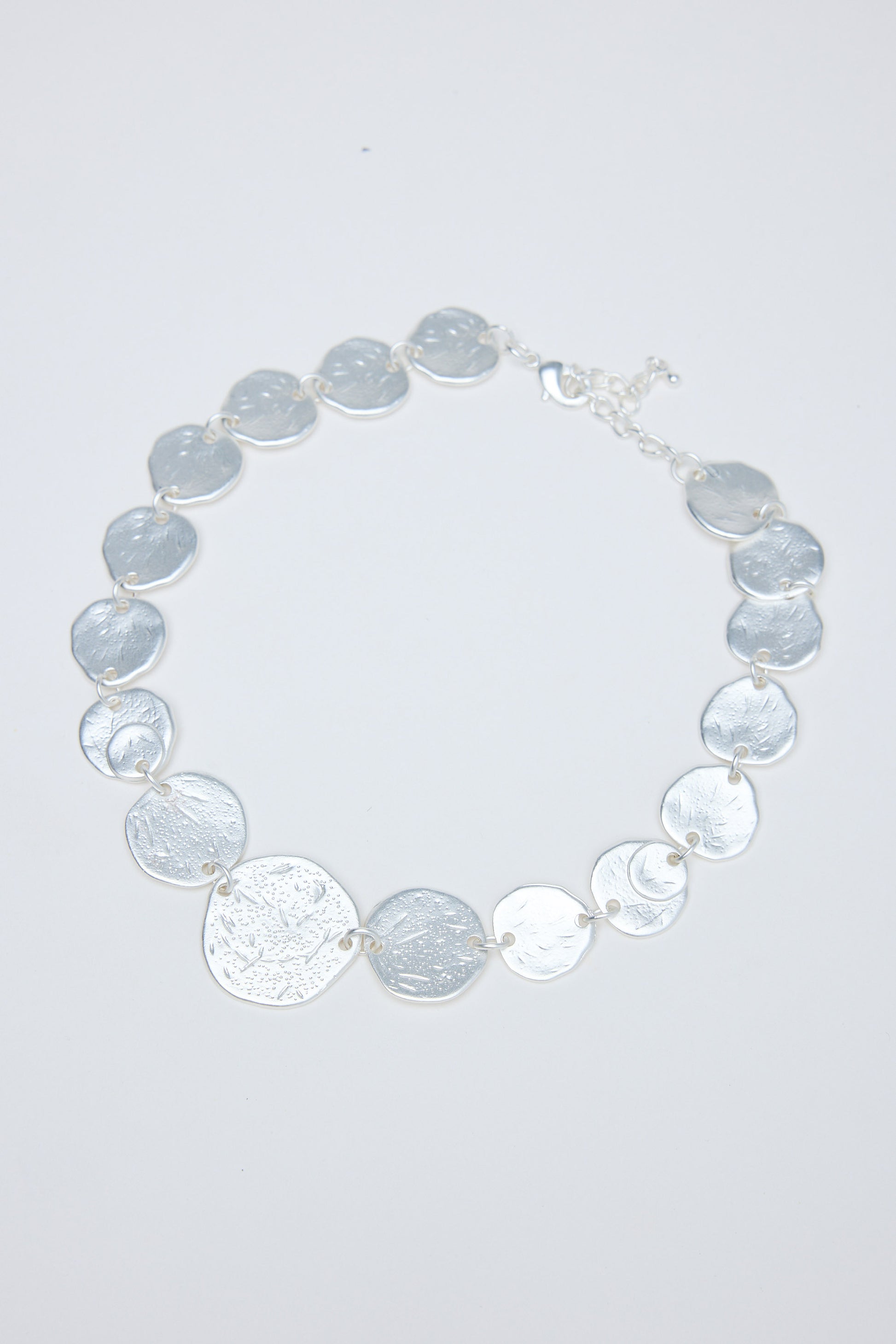 Necklace with gray and silver circular coins on a white background