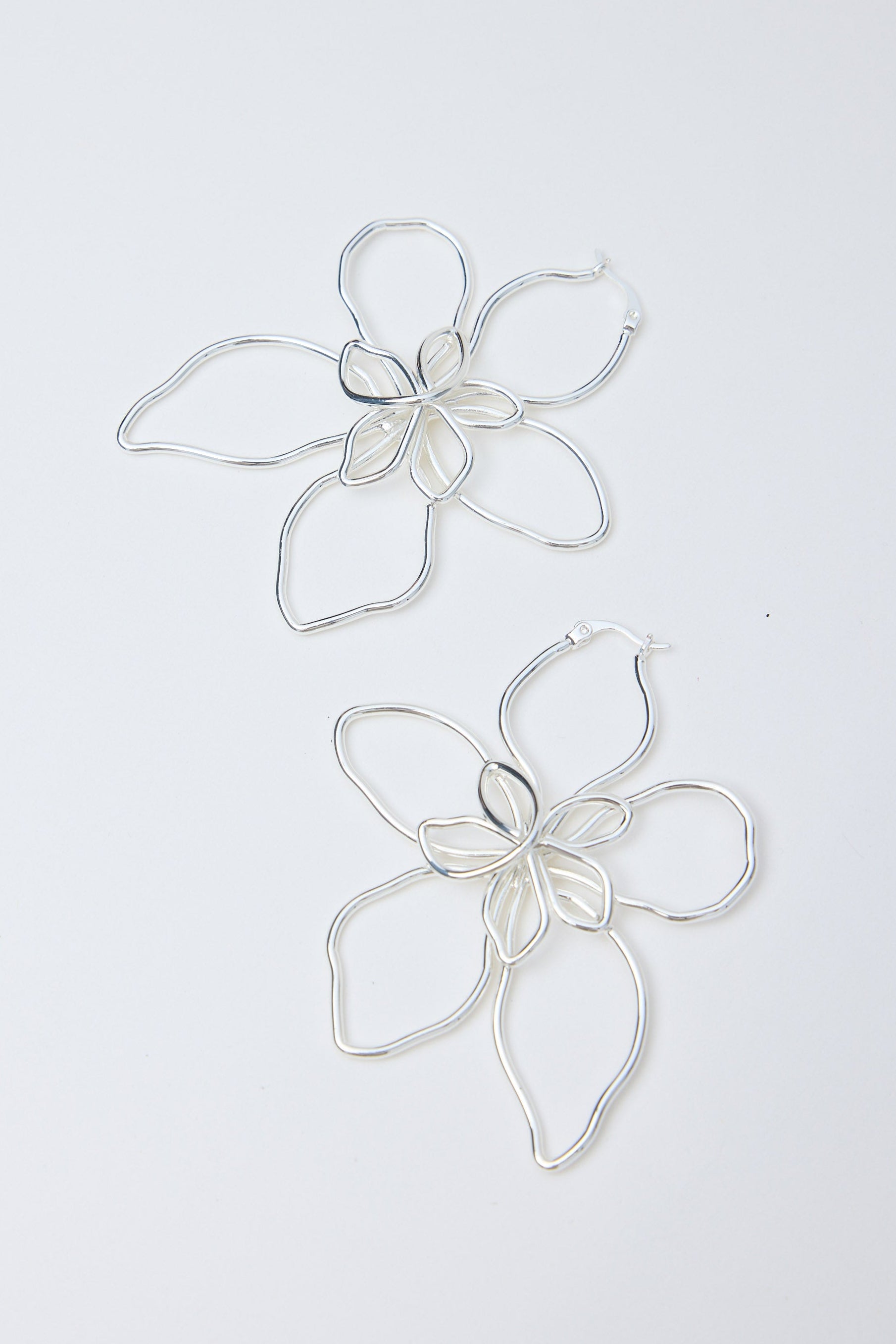 Silver flower-shaped earrings on a white background
