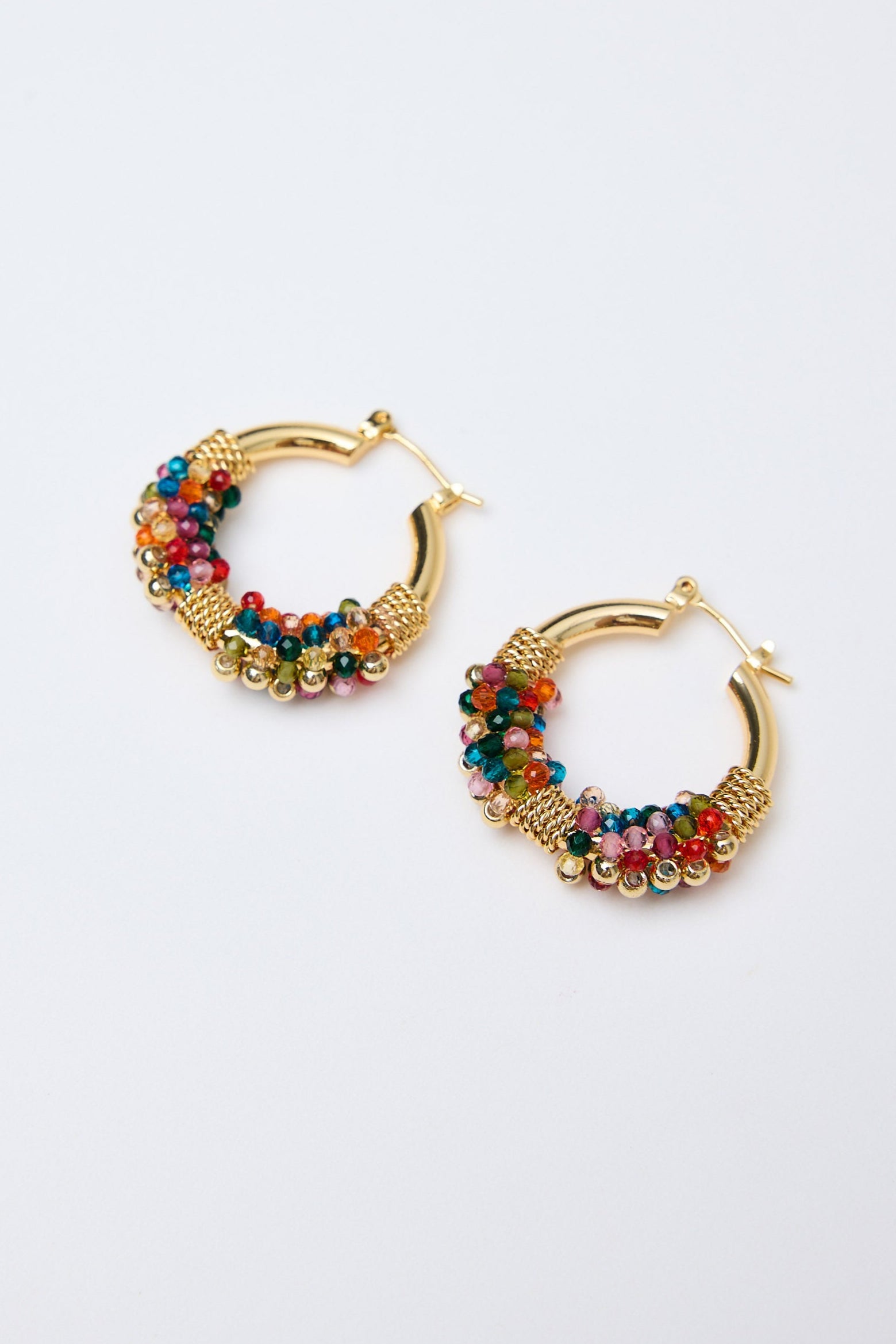 Gold hoop earrings with colorful beads on a white background