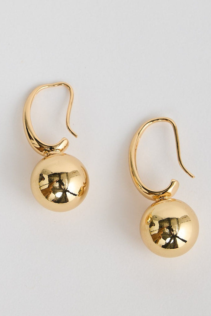 Pair of gold earrings on a light gray background