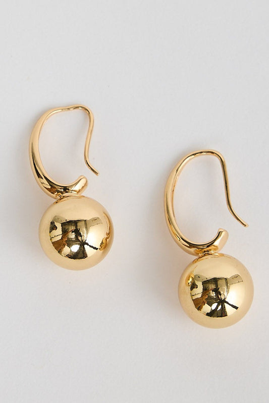 Pair of gold earrings on a light gray background