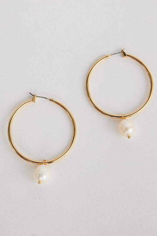 Gold hoop earrings with pearl accents on a light gray background