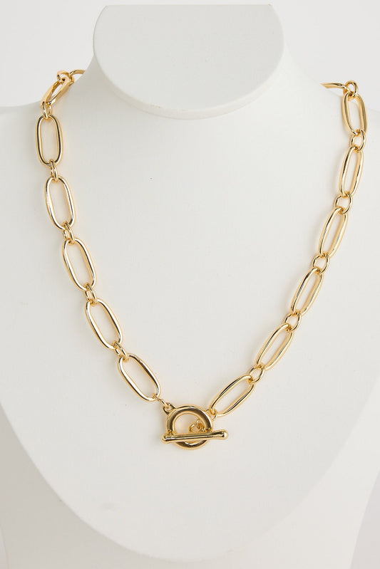 Gold chain necklace on a mannequin bust against a white background