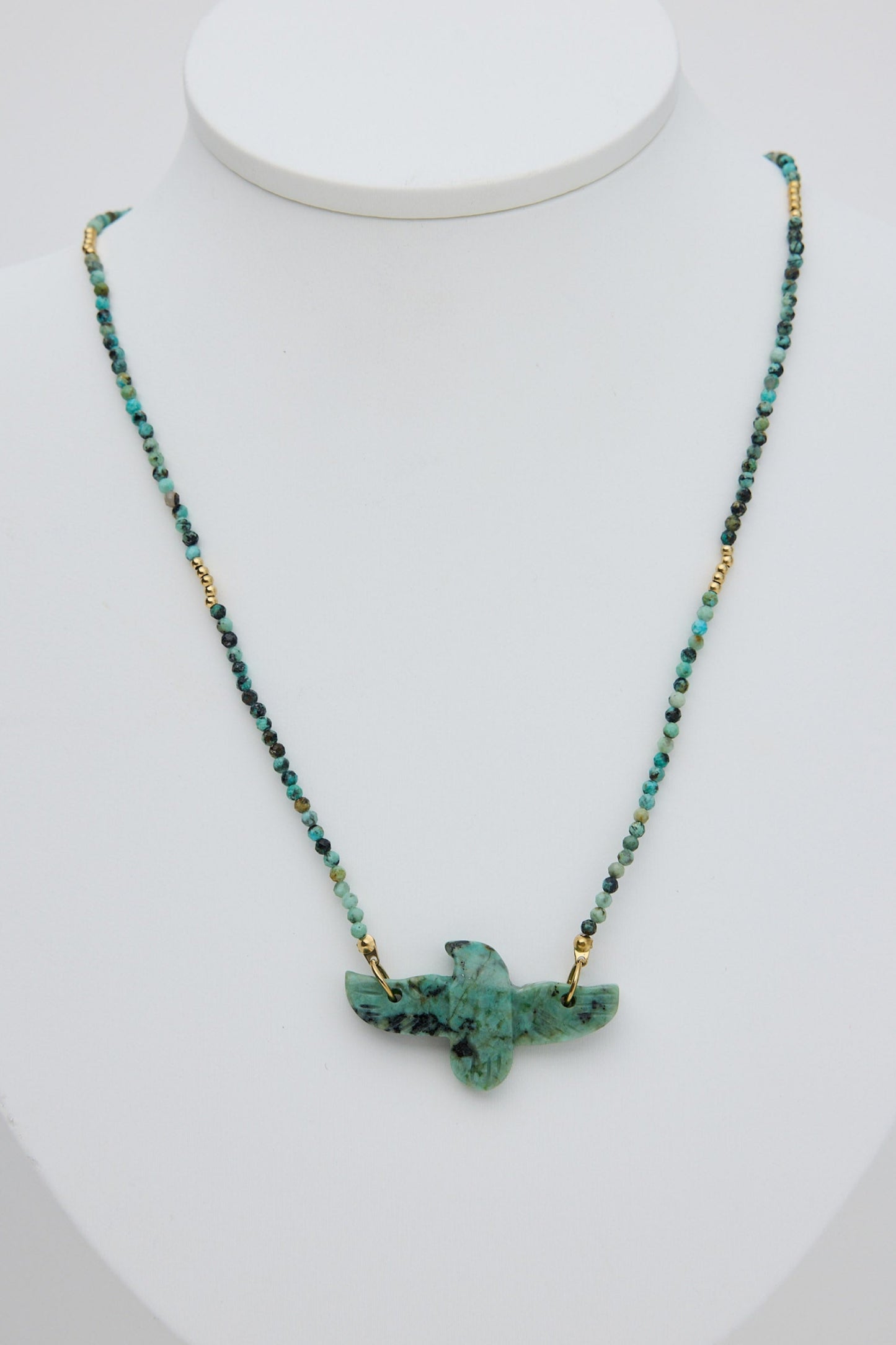 Necklace with a green pendant on a white mannequin bust
