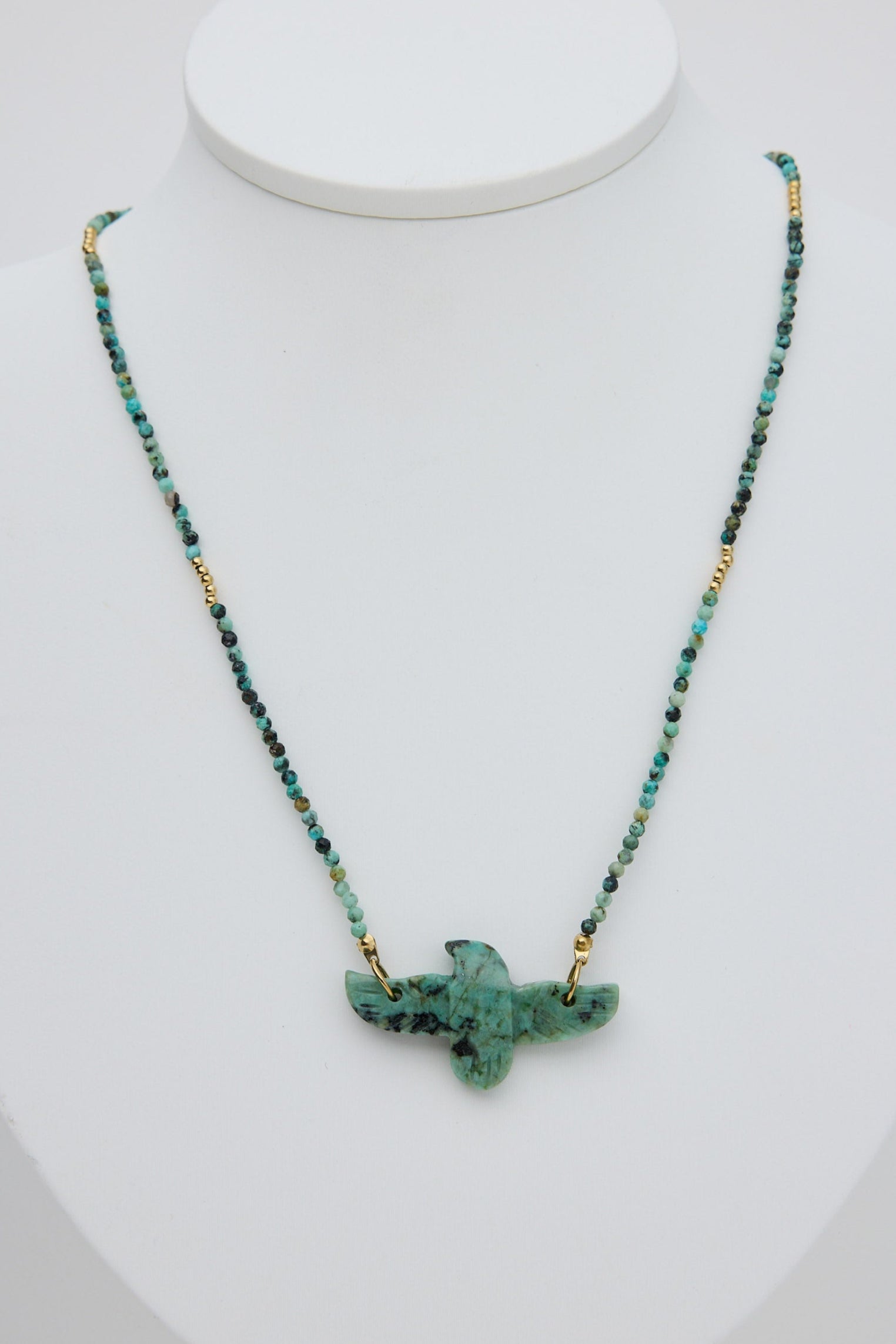 Necklace with a green pendant on a white mannequin bust