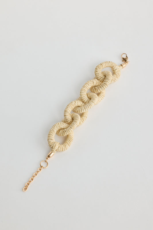 Cream-colored braided bracelet on a light gray background