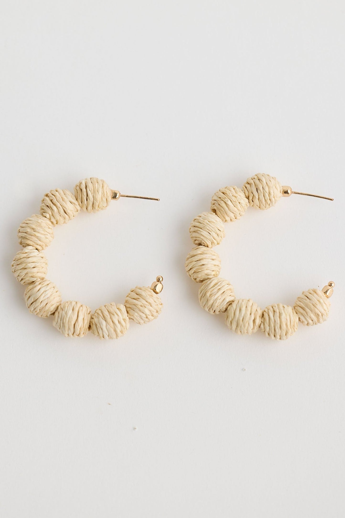 Close-up of natural waldorf hoops earrings on white background.