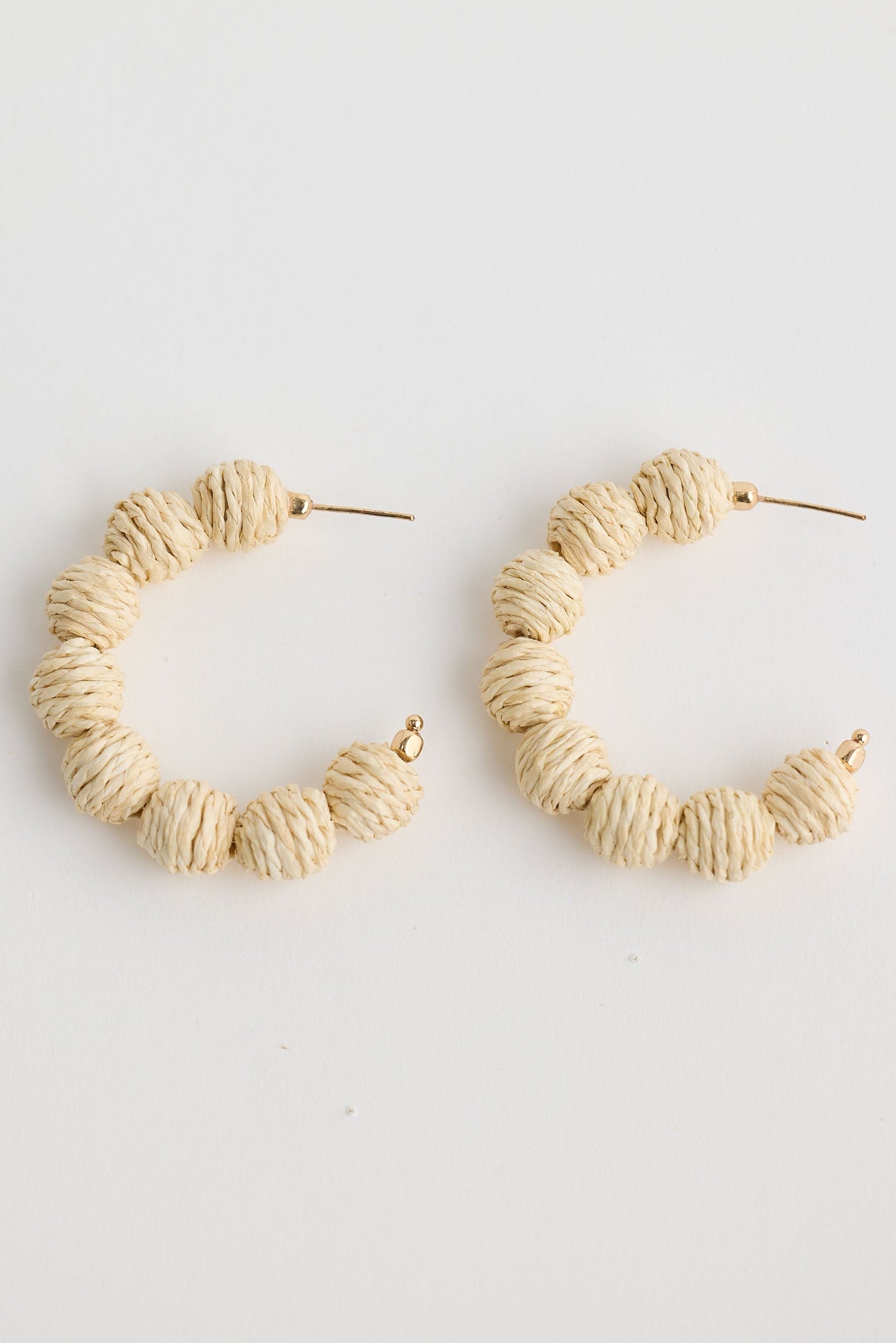 Close-up of natural waldorf hoops earrings on white background.