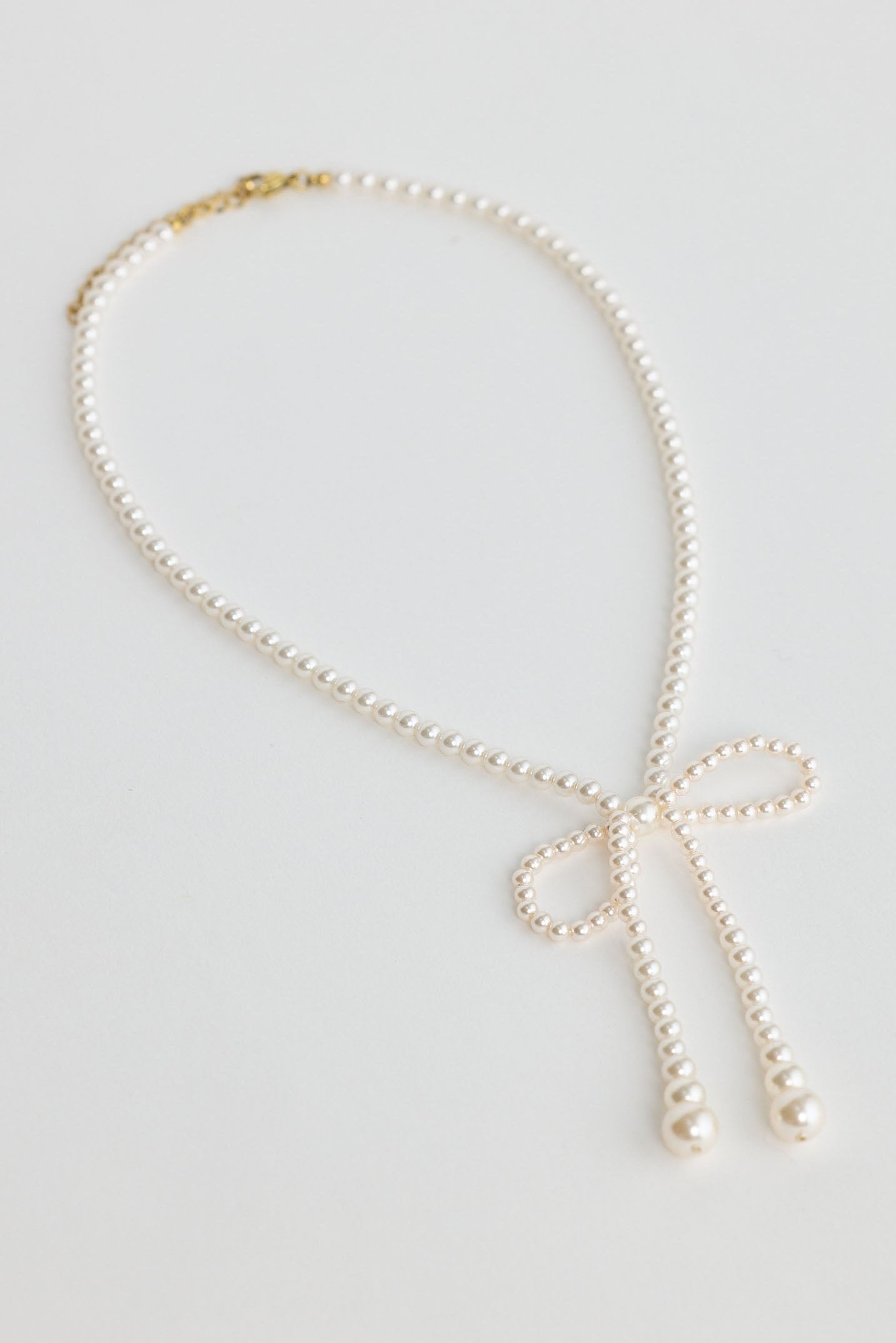 Close-up of pearl ella necklace necklace on white background.