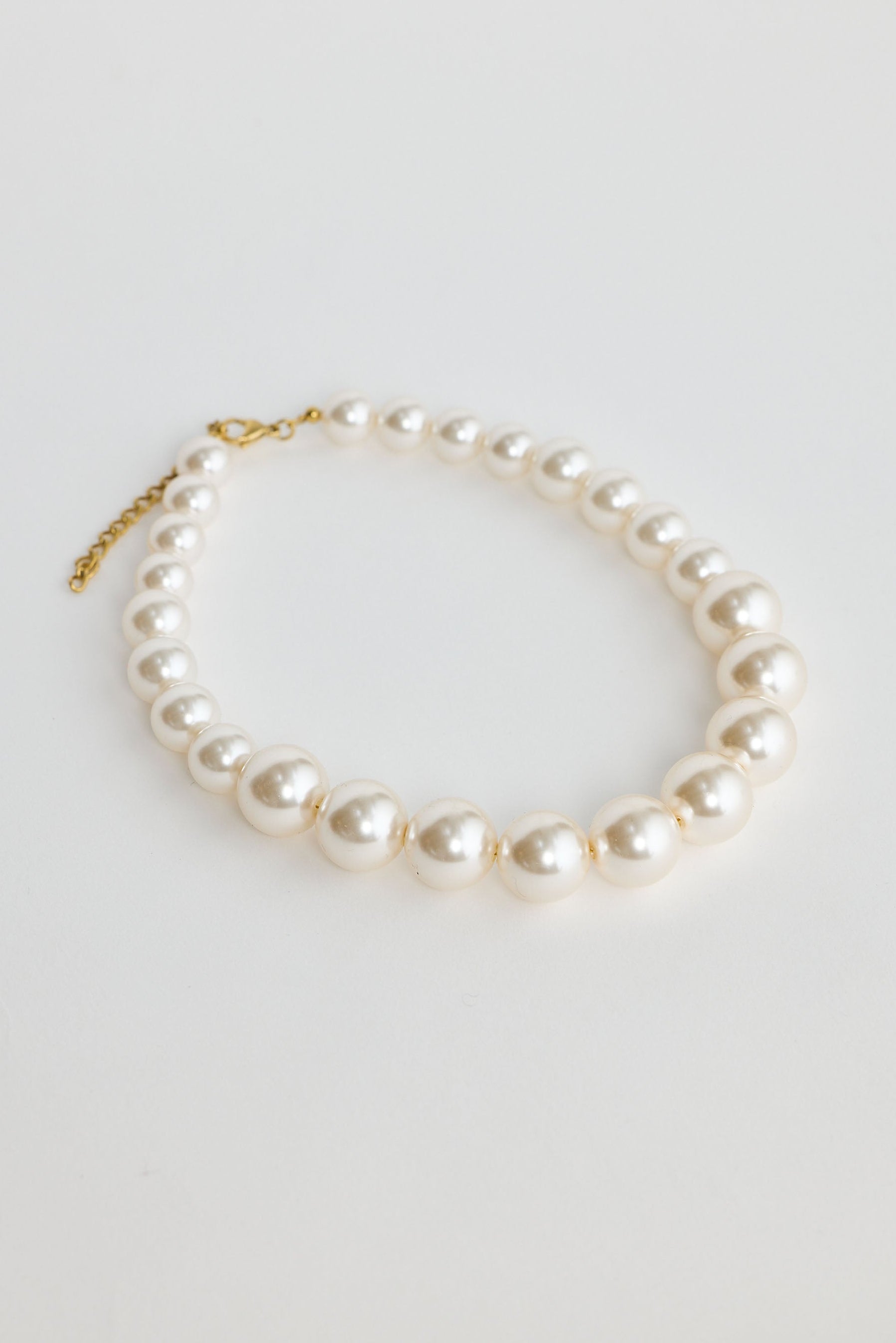 Pearl necklace on a light gray background