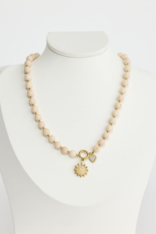 Close-up of bone serenity necklace necklace on white background.