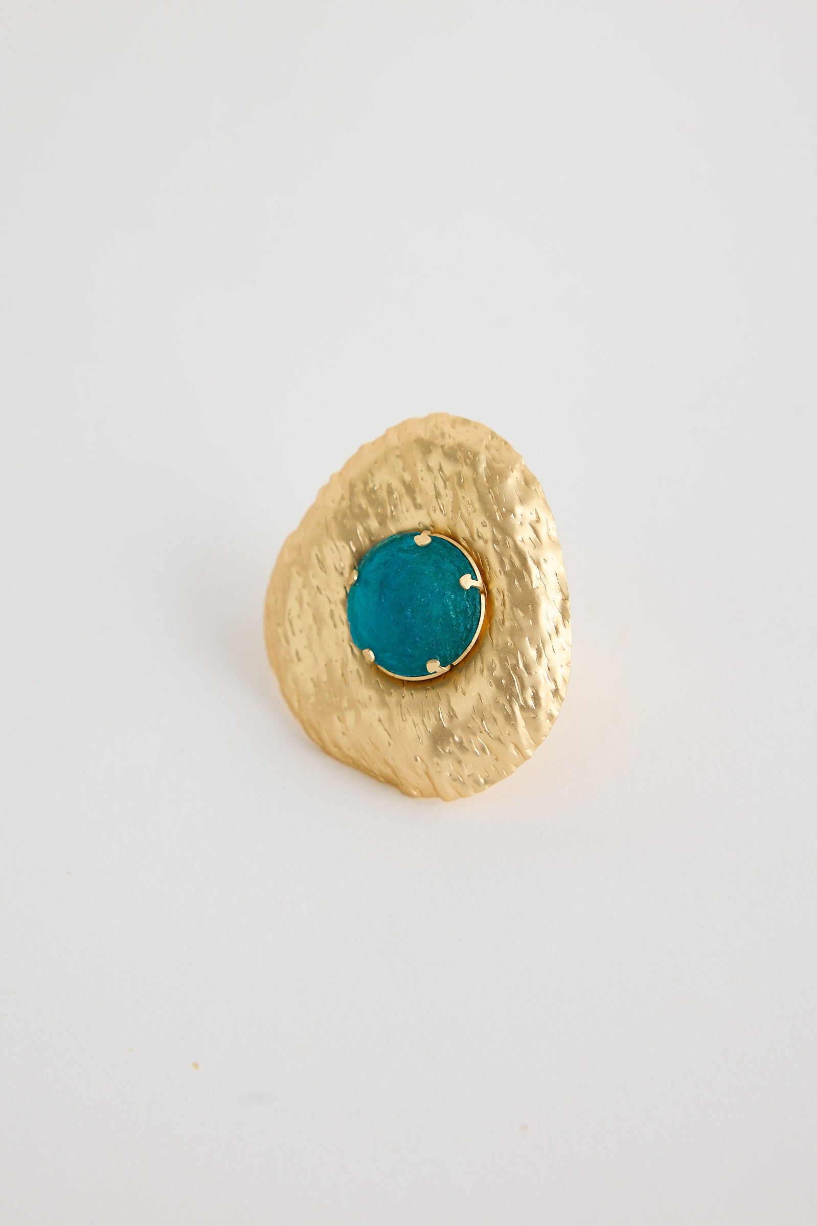 Gold ring with a turquoise gemstone on a white background