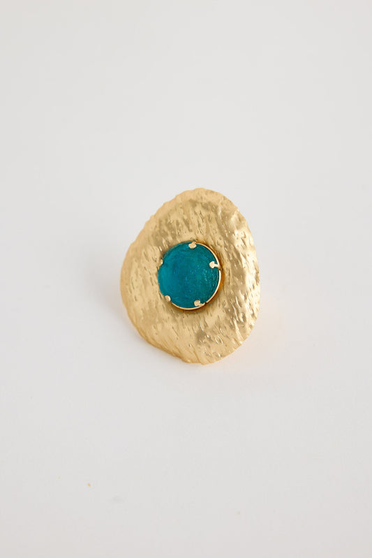 Gold ring with a turquoise gemstone on a white background