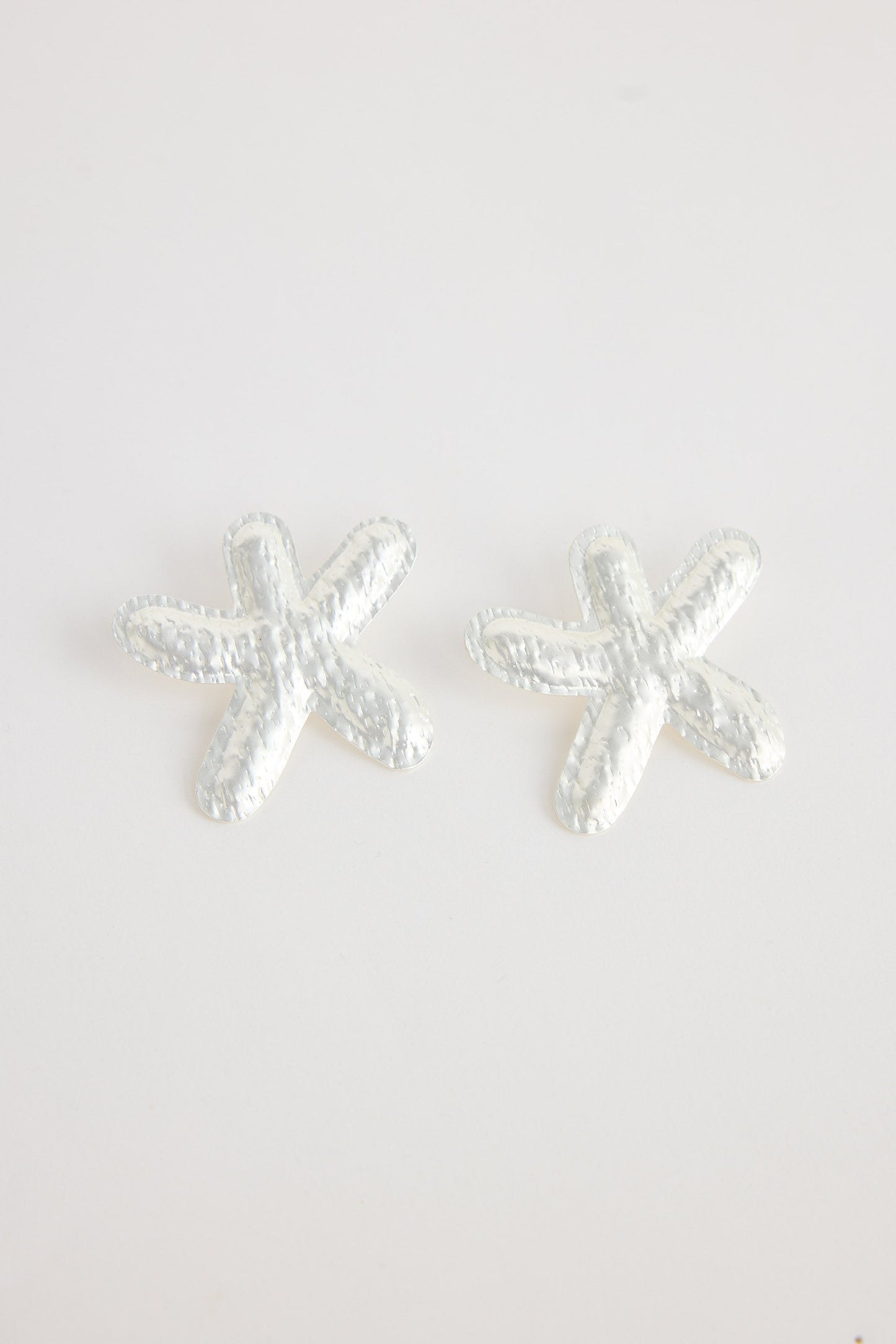 Silver starfish-shaped earrings on a white background