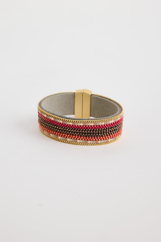 Beaded bracelet with red and gold accents on a light gray background