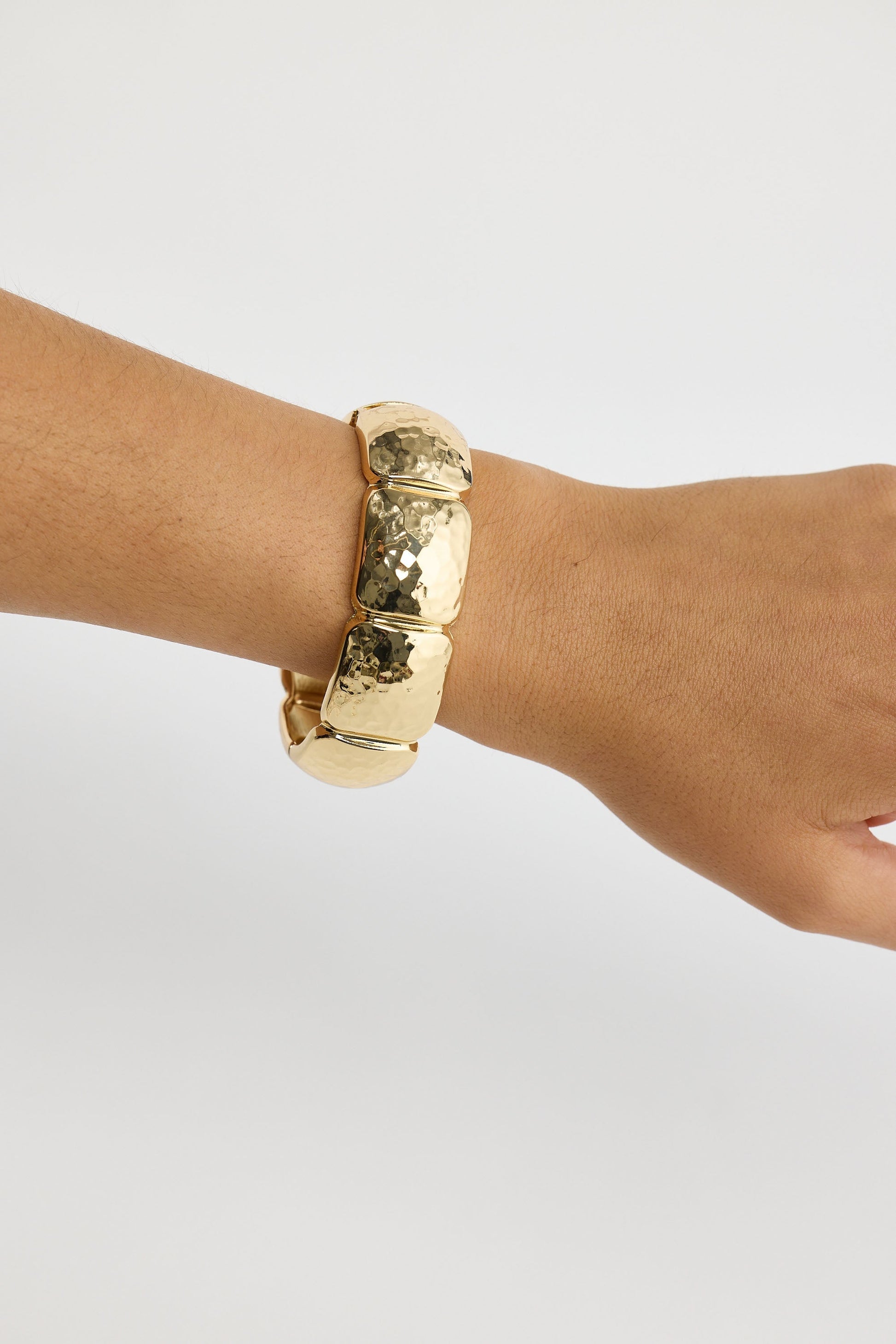 Close-up of gold monterey bracelet bracelet on white background.