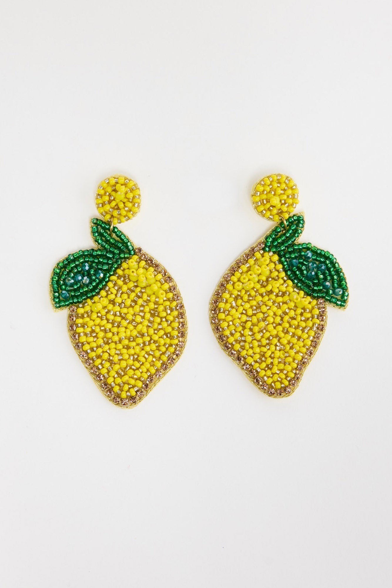 Pair of large beaded lemon drop earrings in bright yellow seed beads with a gold crystal border and green beaded leaf detail, with a round yellow beaded stud, laid flat on a white background