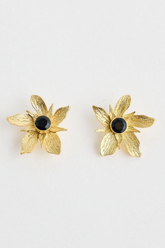 Gold flower-shaped earrings with black centers on a white background