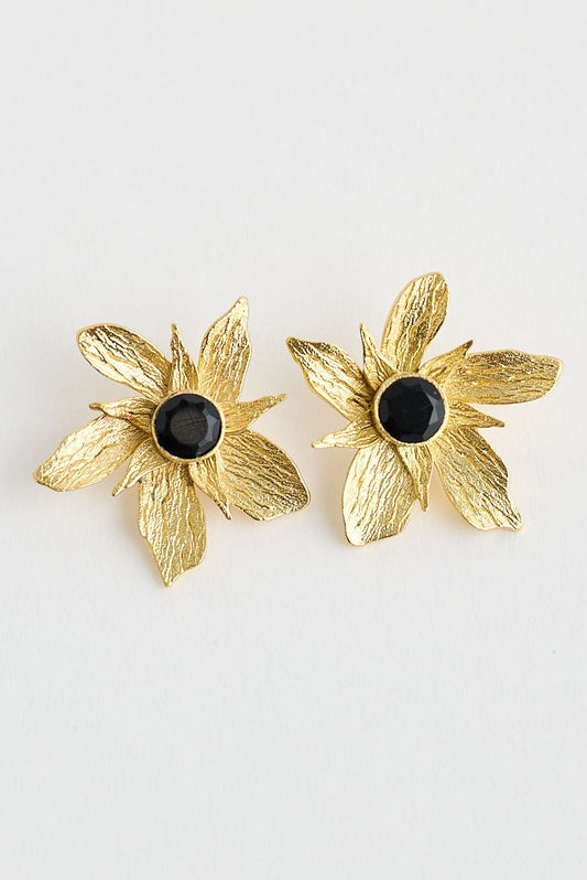 Gold flower-shaped earrings on a light gray background