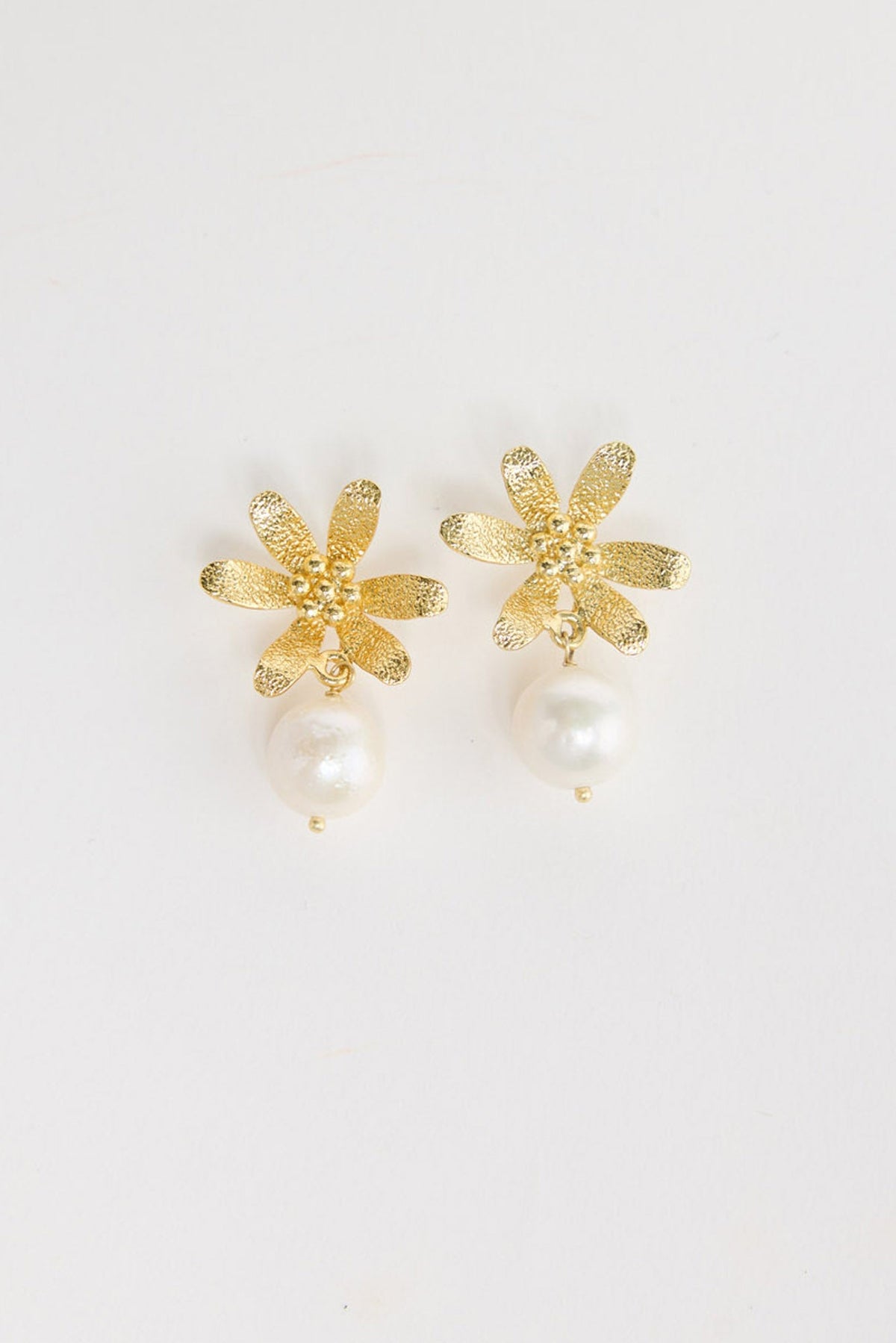 Pair of gold-tone square stud earrings with a freshwater pearl drop and a small gold bead below, laid flat on a white background