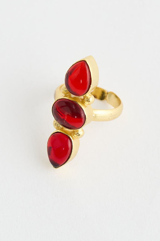 Gold ring with red gemstones on a white background