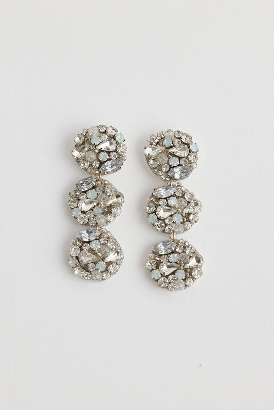 Pair of silver earrings with gemstones on a light gray background