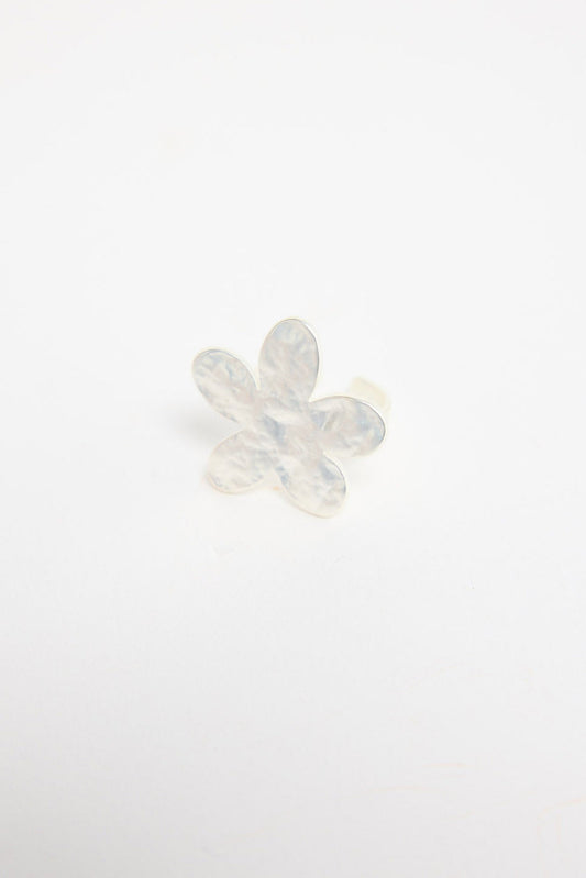 Silver-tone adjustable ring with a large daisy flower top featuring textured petals and a crystal centre, shown at an angle on a white background