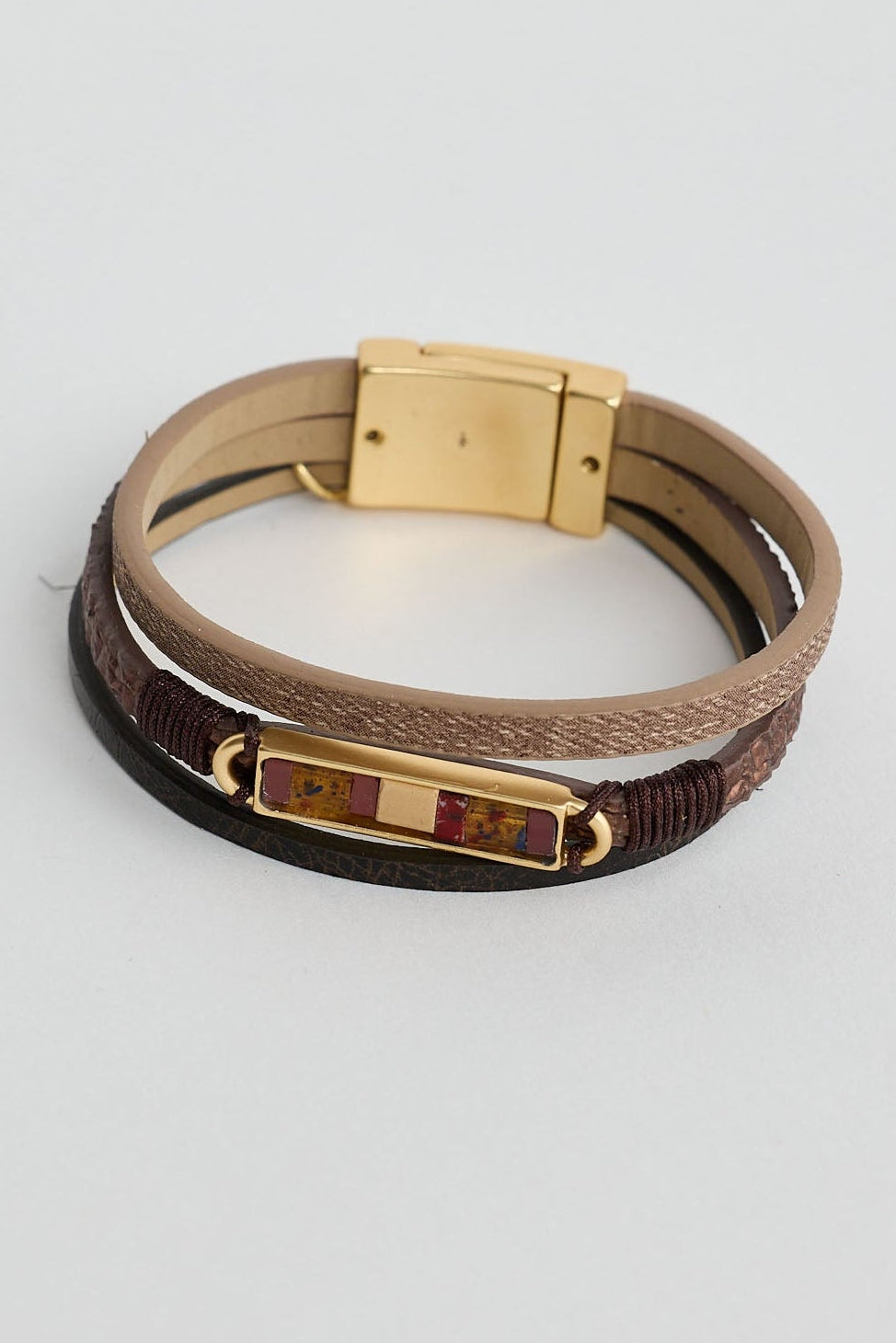 Multistrand bracelet with gold clasp on a light gray background