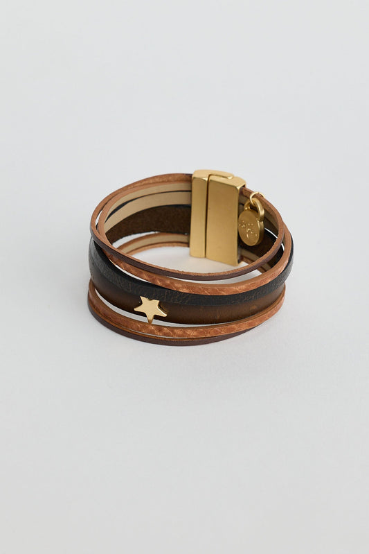Multi-layered leather bracelet with gold clasp on a light gray background