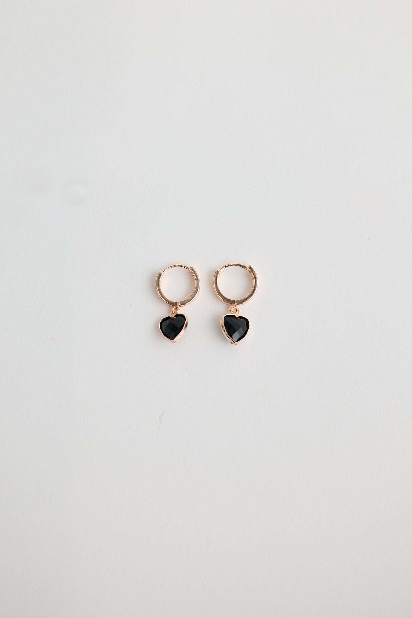 Close-up of black adore earrings earrings on white background.
