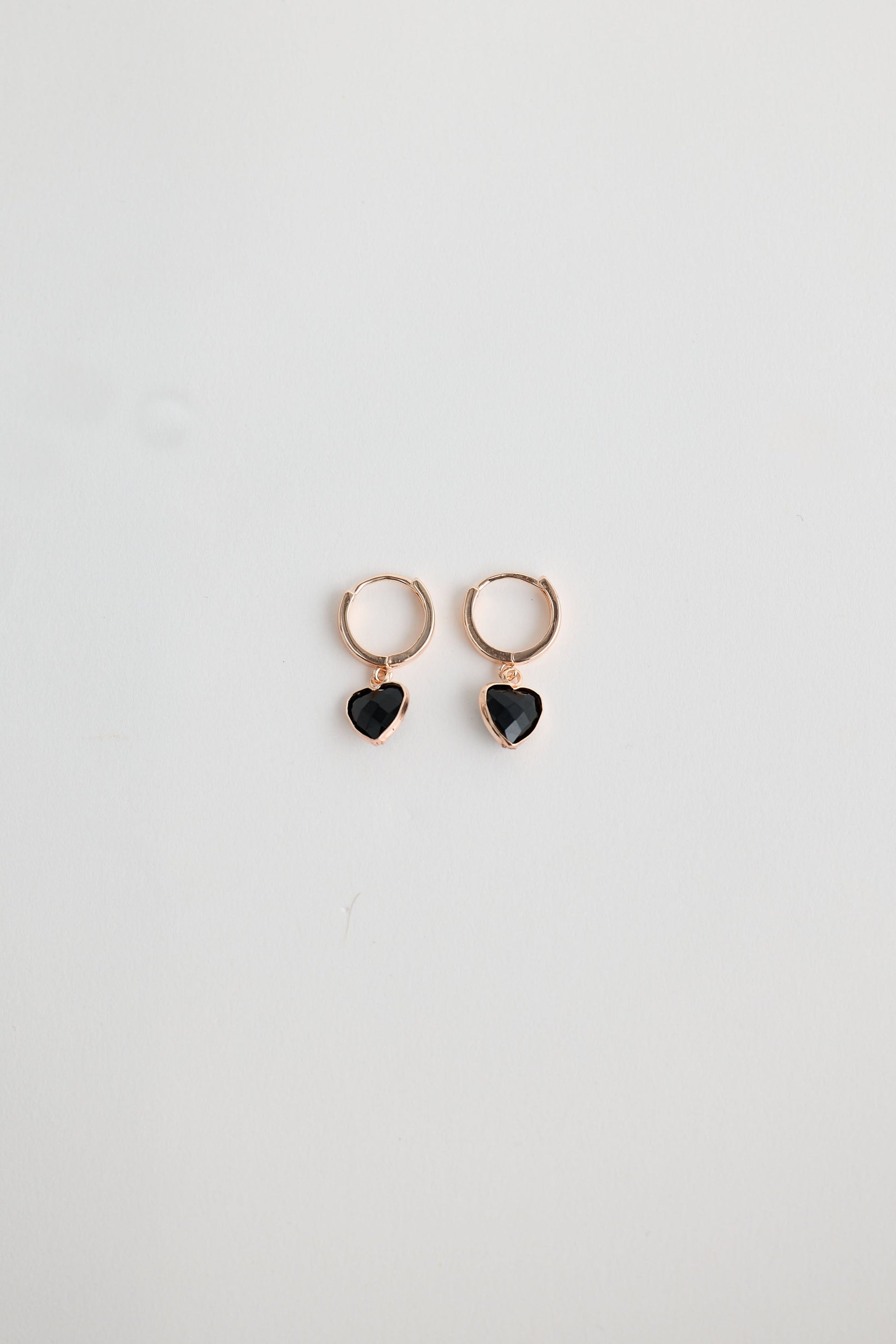 Close-up of black adore earrings earrings on white background.