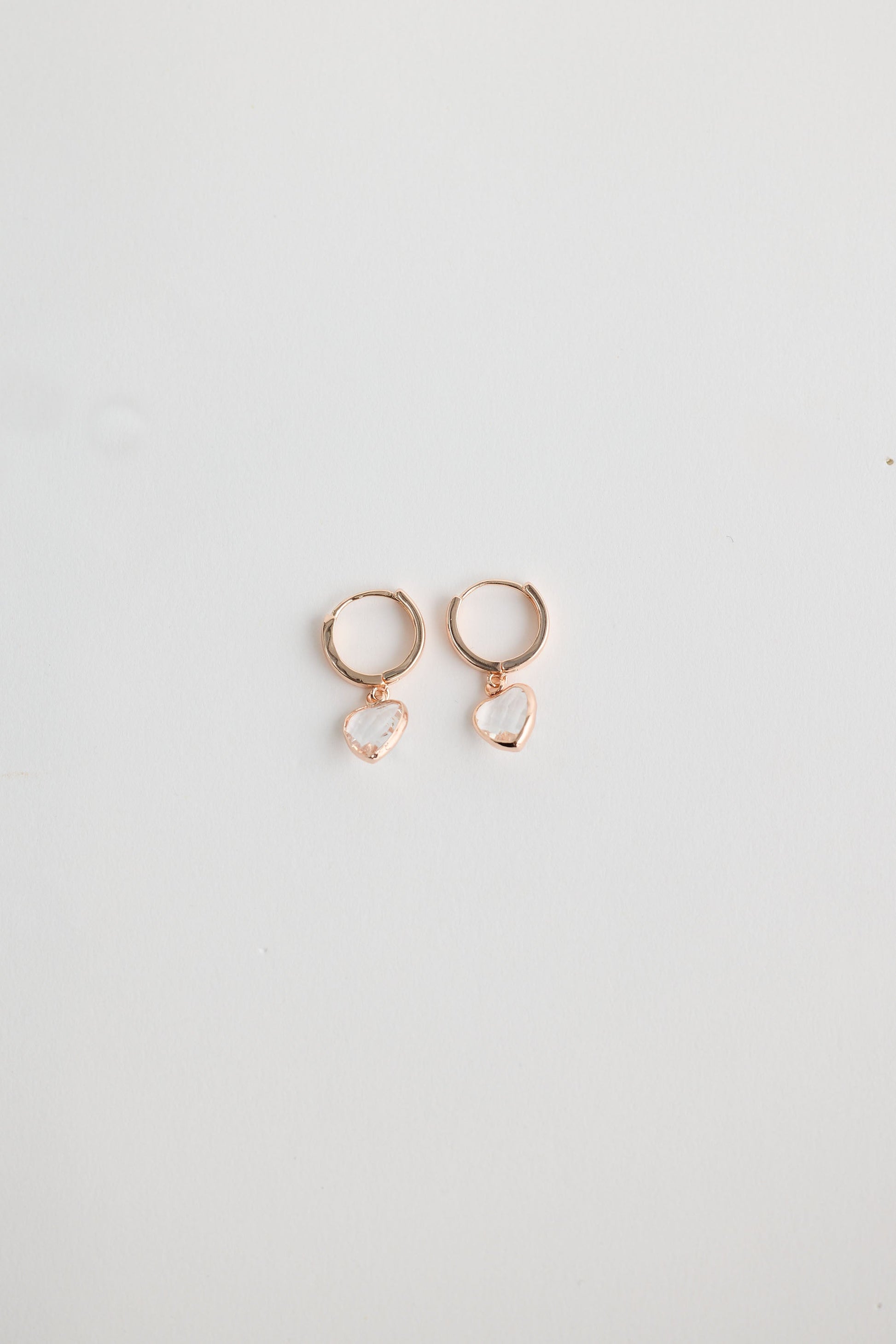 Close-up of clear adore earrings earrings on white background.