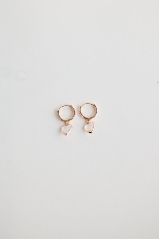 Close-up of clear adore earrings earrings on white background.