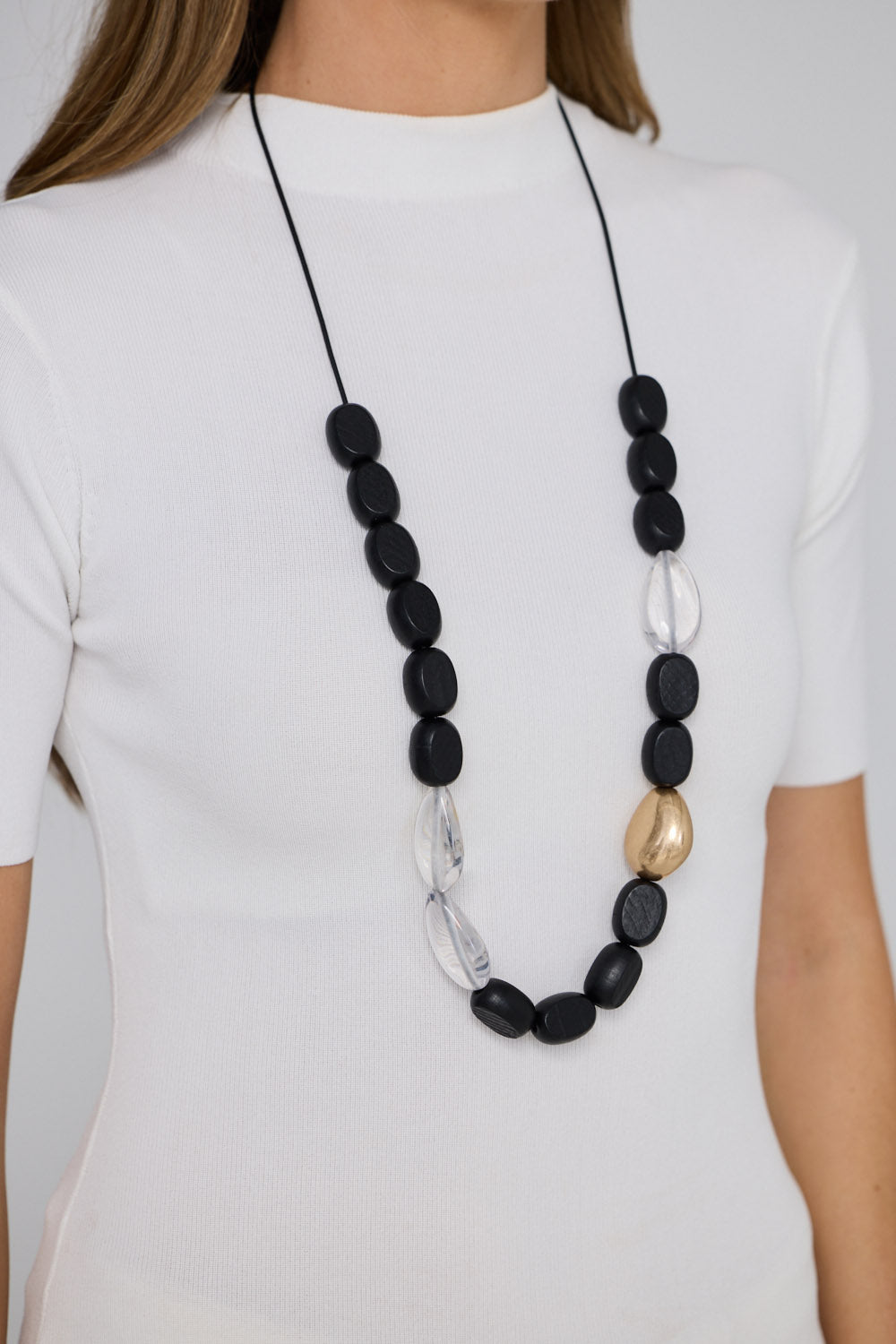 Chester Necklace in black with Gold with mixed material detailing and metal accents, alternate styled view on neutral background