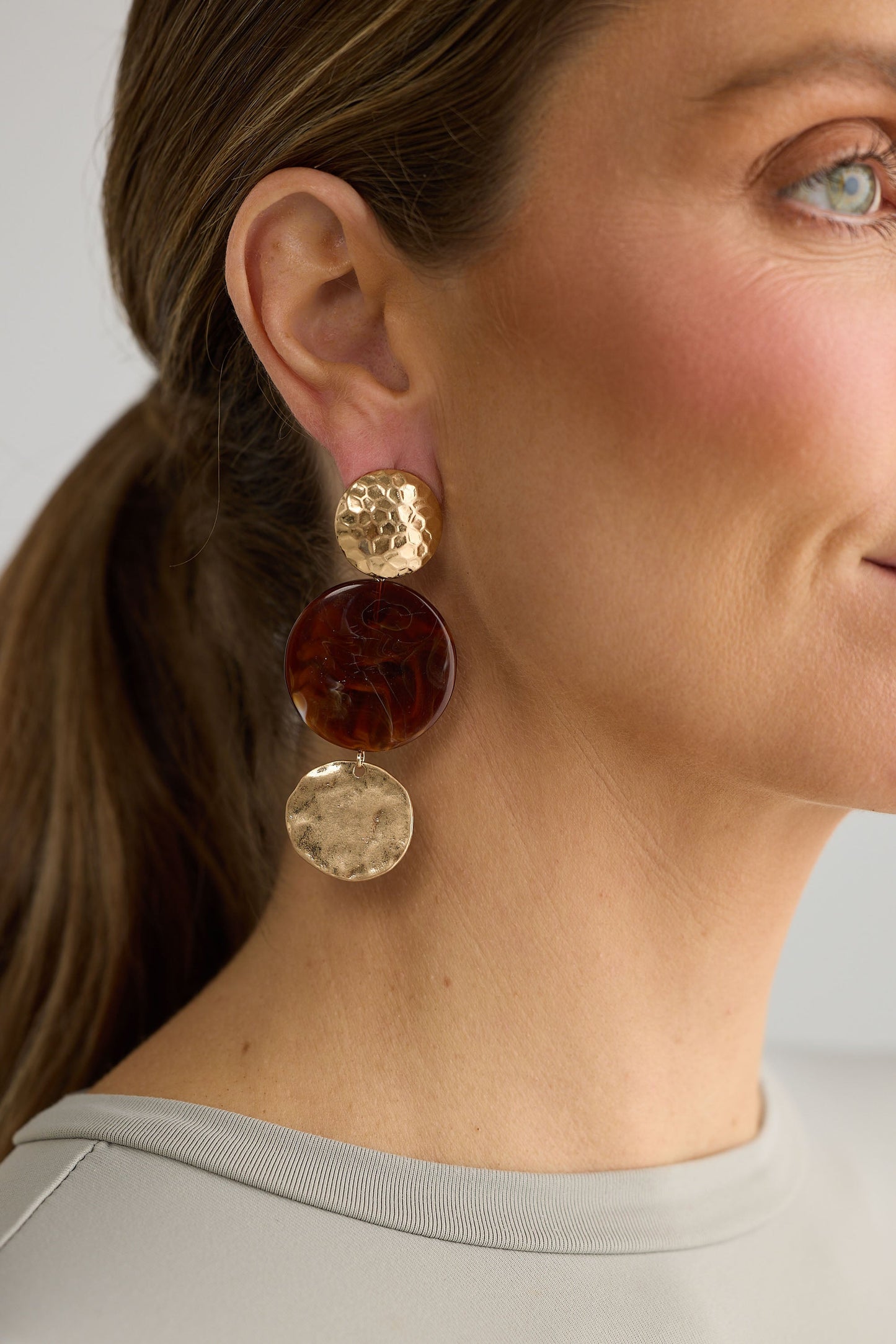 Close-up of amber amara earrings earrings on white background.