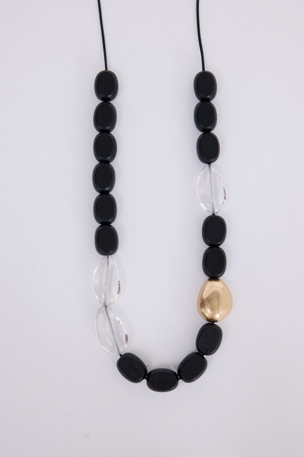 Chester Necklace in black with Gold with mixed material detailing and metal accents, angled view on white background