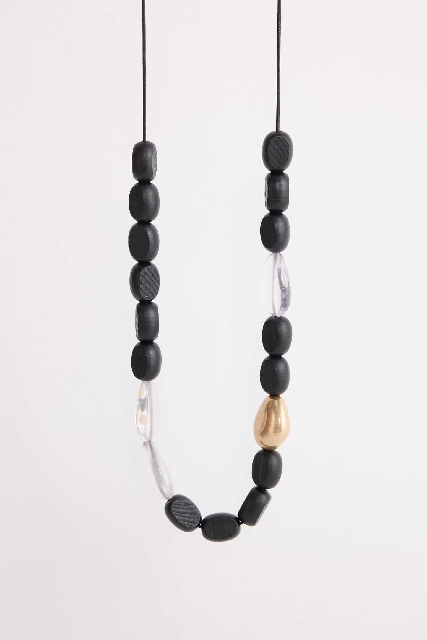 Chester Necklace in black with Gold with mixed material detailing and metal accents, side display view on neutral background