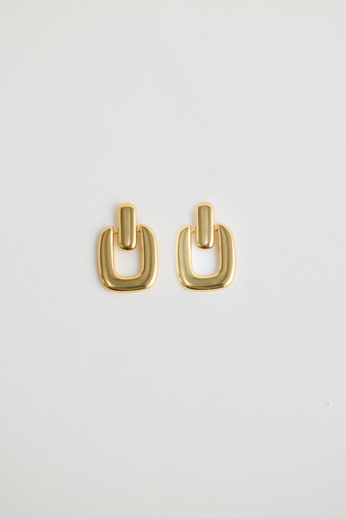 Close-up of gold avery earrings earrings on white background.