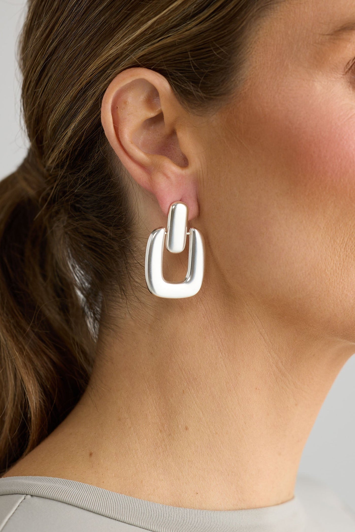 Close-up of silver avery earrings earrings on white background.